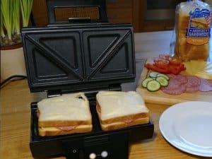 Sandwiches mit Butter bestrichen, Salami und Käse belegt im Krups Sandwichmaker